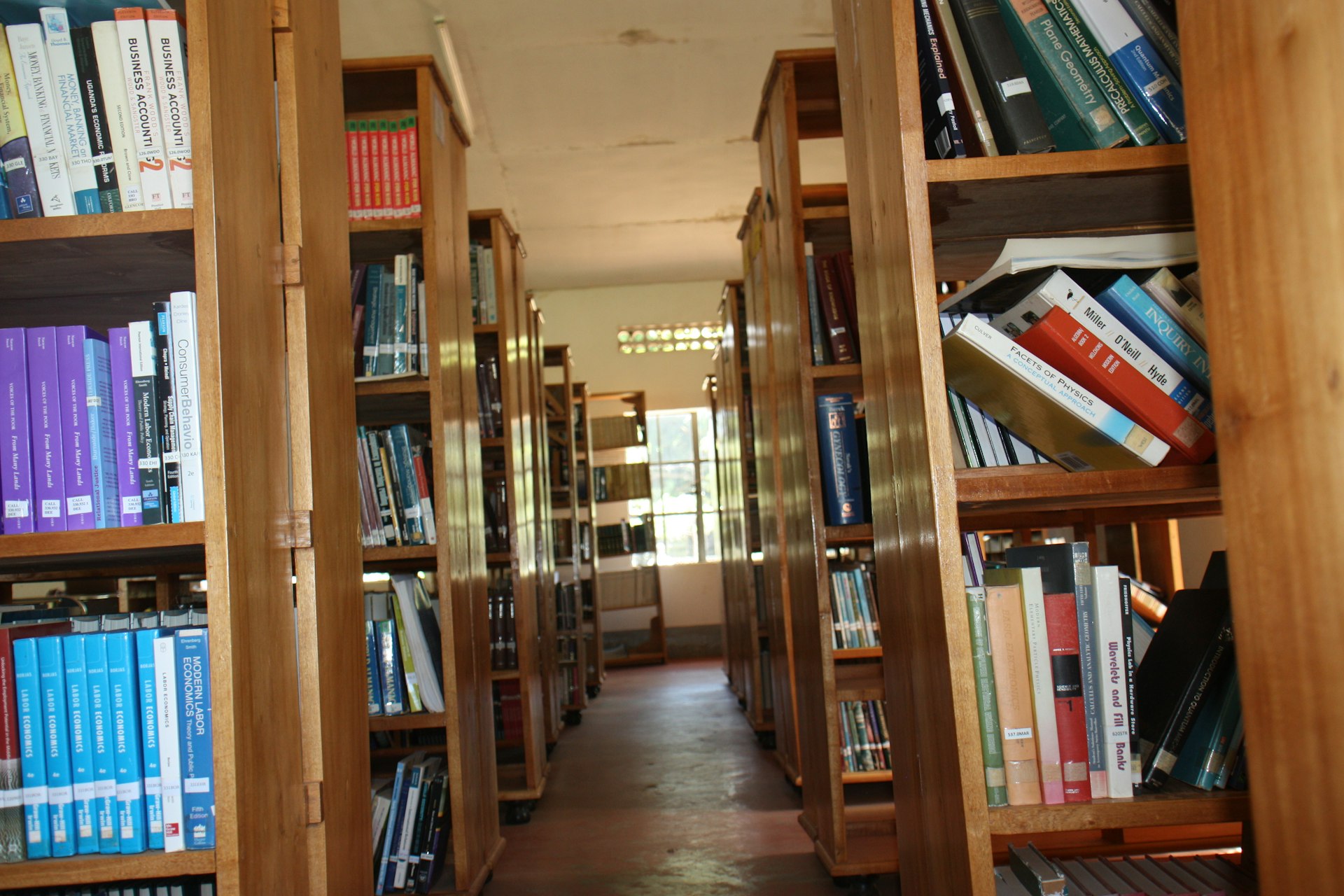 a row of wooden bookshelves filled with lots of books